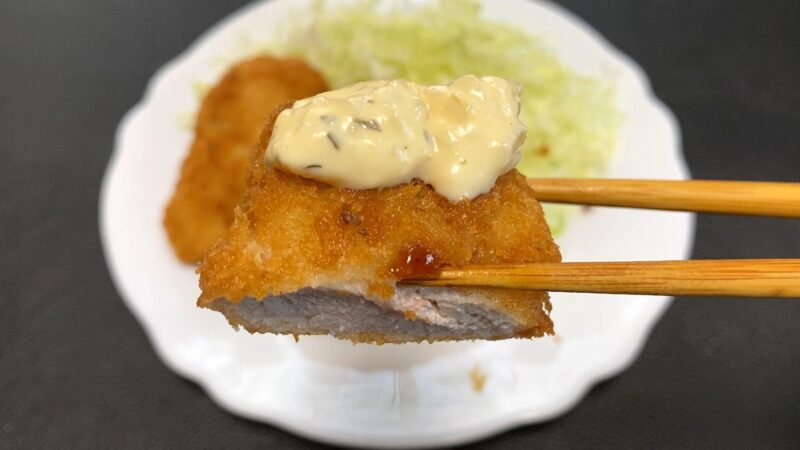 業務スーパー「肉厚 極旨とんかつ」にタルタルソースをのせた写真。ソースのまろやかさが加わり、違った味わいを楽しめる仕上がり。