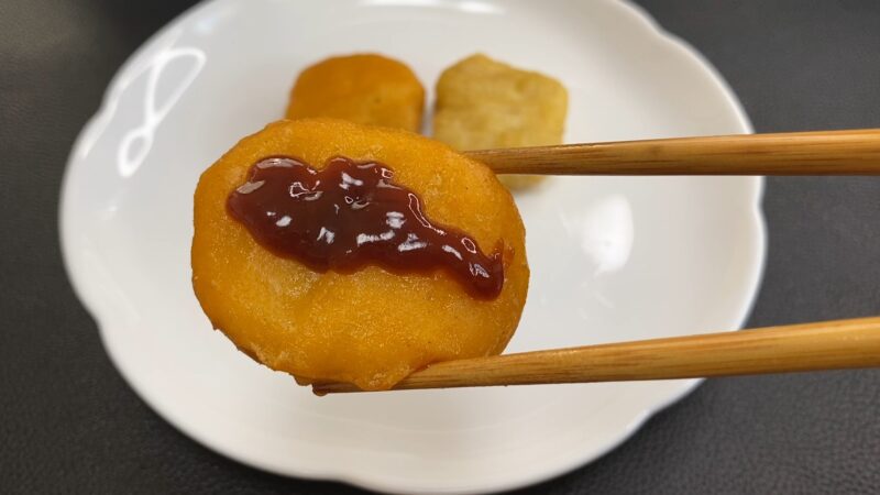 国産チキンナゲットにバーベキューソースをかけた様子。甘辛いソースが表面に広がっている。