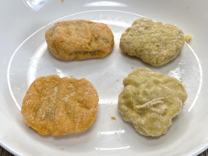 チキンナゲットを4個並べた比較写真。衣の色や形の違いがわかり、国産タイプは明るくやや小ぶりな印象。