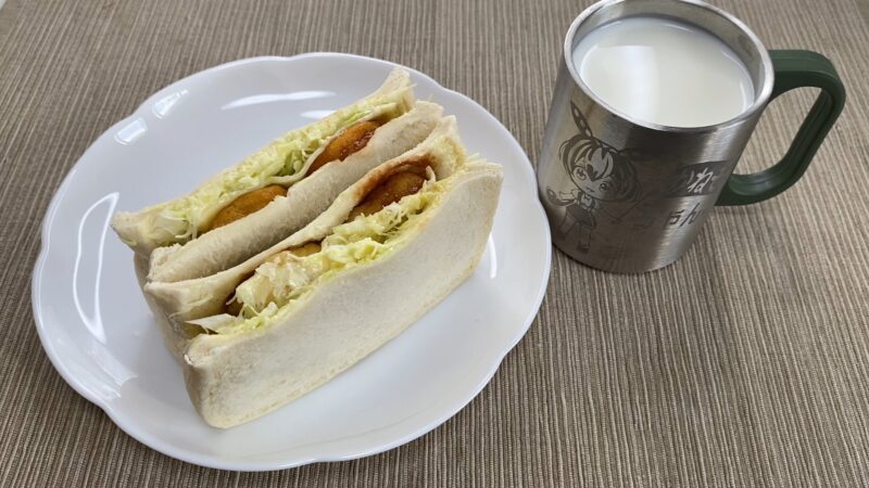 国産チキンナゲットをパンに挟んだサンドイッチとミルクのセット。皿に2つ並べて、朝食風に仕上げた。