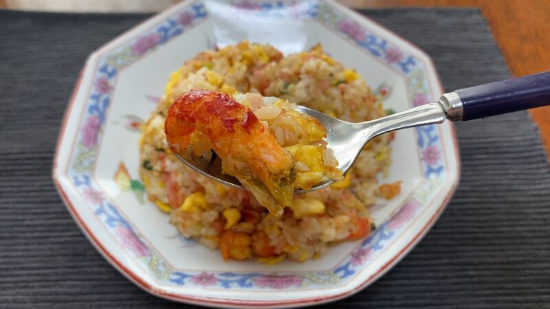 スプーンで持ち上げたザリガニ炒飯。プリッとした赤い身とふんわり卵が見える。