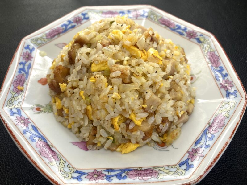 業務スーパーの和風鶏もも唐揚げを使ったチャーハン。卵とご飯に刻んだ唐揚げを混ぜ込んだ香ばしい仕上がり。中華皿にこんもり盛りつけられている。