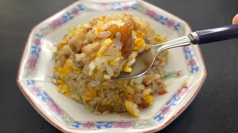 唐揚げチャーハンをスプーンですくって食べる直前の様子。ご飯に唐揚げの一切れがしっかり混ざっており、香ばしさとボリューム感が伝わる一枚。