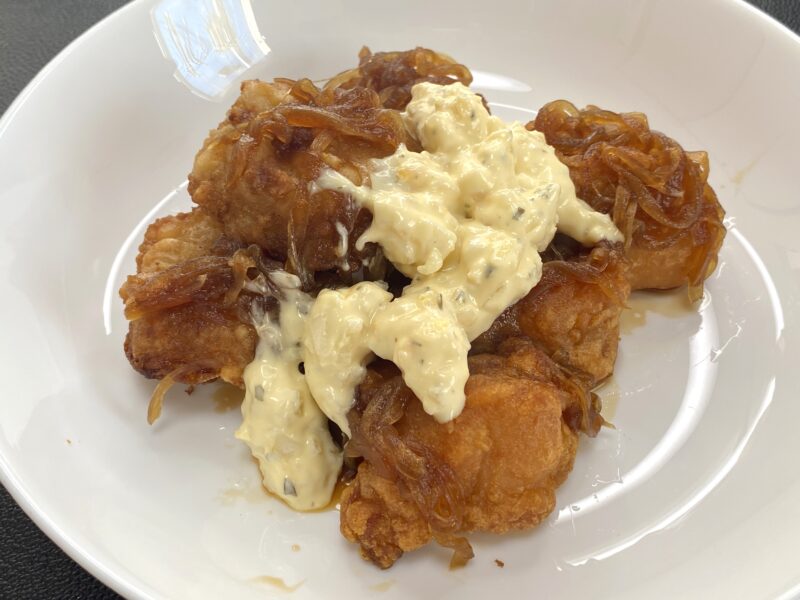 業務スーパーの和風鶏もも唐揚げをアレンジしたチキン南蛮。玉ねぎ入りの甘酢あんとタルタルソースがたっぷりかかっている。家庭的でボリューム満点な一皿。