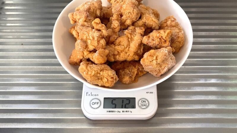 業務スーパー「和風鶏もも唐揚げ」を皿に盛り、キッチンスケールで計量した写真。合計512gと表示されている。内容量の検証シーン。