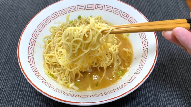 替え玉を加えた一蘭ラーメンを箸で持ち上げている写真。スープが麺に絡み、再び食欲をそそる状態。