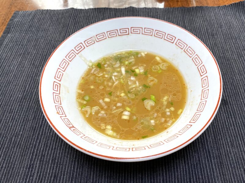一蘭ラーメンを食べ終えた後のスープ。ネギが浮かび、替え玉やアレンジに使える状態。