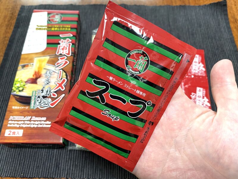 一蘭ラーメン専用のスープ袋を手に持った写真。赤と緑のストライプが特徴。
