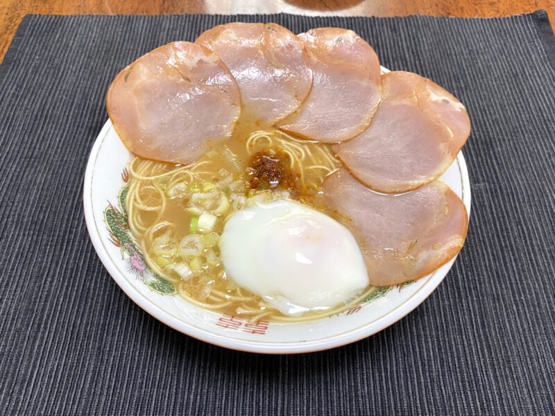 一蘭ラーメンに温泉卵とチャーシューをトッピングした写真。贅沢なアレンジで豪華な見た目。