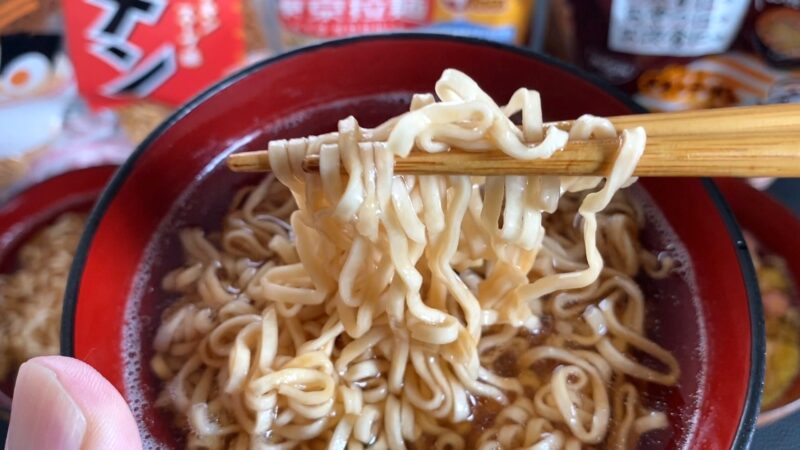 東京拉麺チキン味の麺を箸で持ち上げたアップ写真。ツヤのある麺がスープをまとい、シンプルな香ばしさを感じさせる。