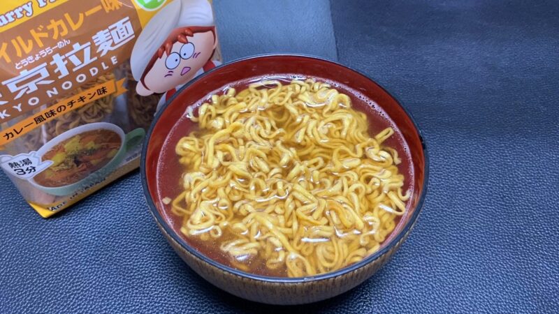 東京拉麺マイルドカレー味を器に盛った状態。スープは黄色みがかったカレー色で、麺がたっぷり入っている。