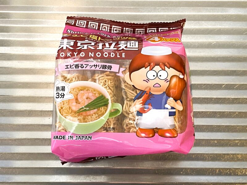 東京拉麺エビ塩トンコツ味のパッケージ。ピンクの袋に、エビと骨付き肉を持ったキャラクターが描かれている。
