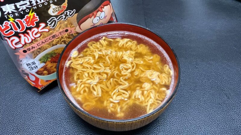 東京拉麺ピリ辛にんにく味を器に盛った状態。赤みのあるスープが特徴で、香ばしいにんにくの香りを感じさせる見た目。