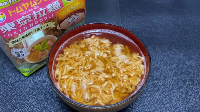 東京拉麺トムヤンクン味を器に盛った状態。赤みがかったスープに麺が浮かび、酸味と辛味を感じさせる見た目。
