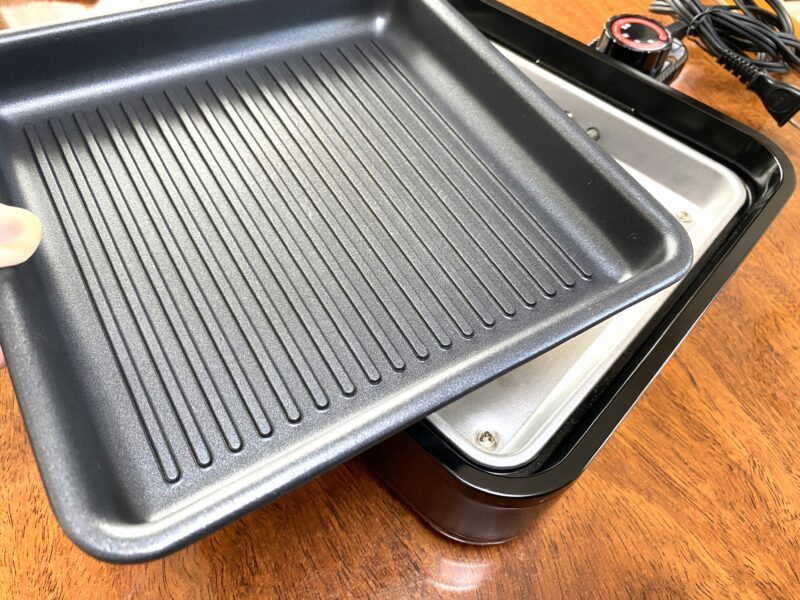 山善ホットプレート YHC-W601 の波型プレートを取り外している様子。プレートは着脱式で、使用後は外して丸洗いできる。