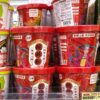 業務スーパーの店頭に並ぶ酸辣粉（サンラーフン）のカップ麺。赤いパッケージが目を引き、隣には白い酸湯面叶も陳列されています。