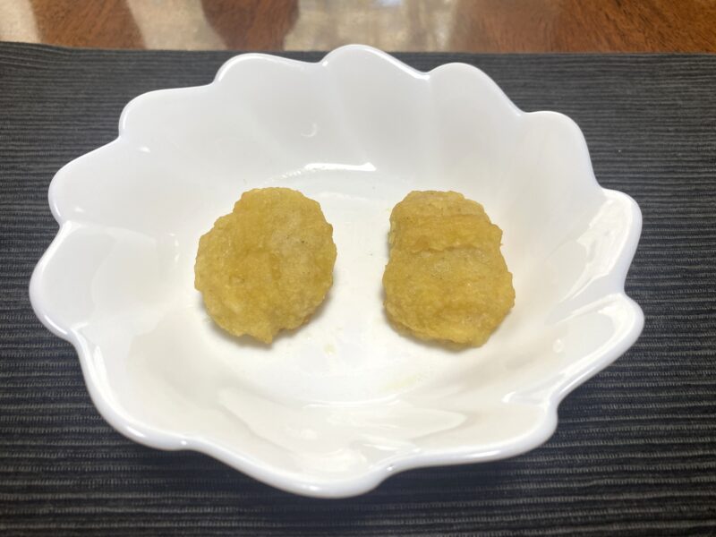 白い皿にチキンナゲットを2個並べ、電子レンジで加熱した状態。衣がややしっとりしている様子。