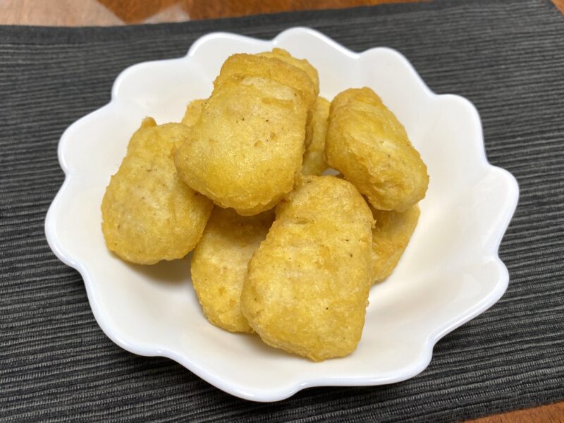 揚げたてのチキンナゲットを白い皿に盛りつけた写真。衣が香ばしく色づき、表面に軽いツヤがある。食べる直前の状態。