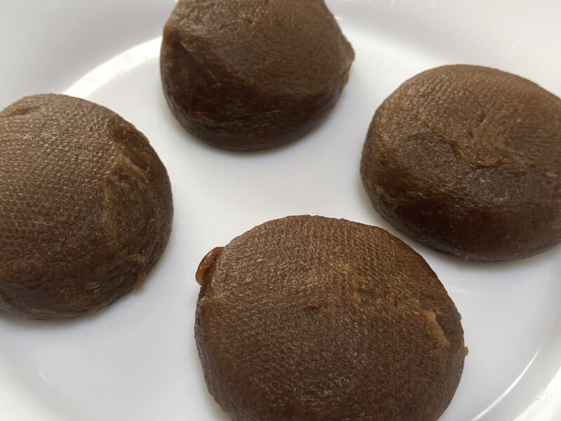 業務スーパー「ホイップクリーム大福(チョコ)」の解凍後をアップで撮影。 チョコ色のお餅の質感がなめらかで、もちもち感が伝わる。