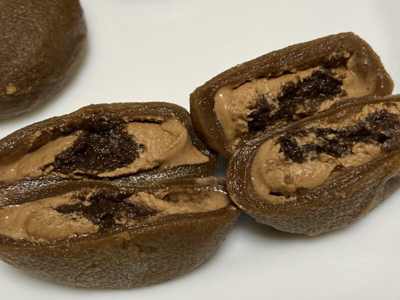 業務スーパー「ホイップクリーム大福(チョコ)」の断面。 中心にチョコソース、その外側にホイップクリーム、さらにお餅が包む3層構造がはっきり見える。