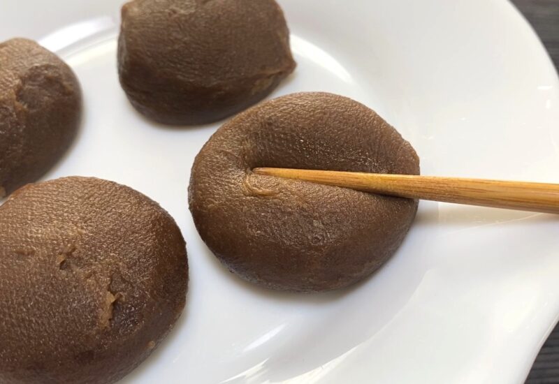 箸で押して弾力を確かめている様子。 業務スーパー「ホイップクリーム大福(チョコ)」のプニプニ感がよくわかる。