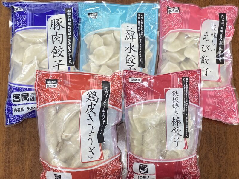 業務スーパーで購入した冷凍餃子5種類（豚肉・三鮮・えび・鶏皮餃子・棒餃子）のパッケージを並べた写真。