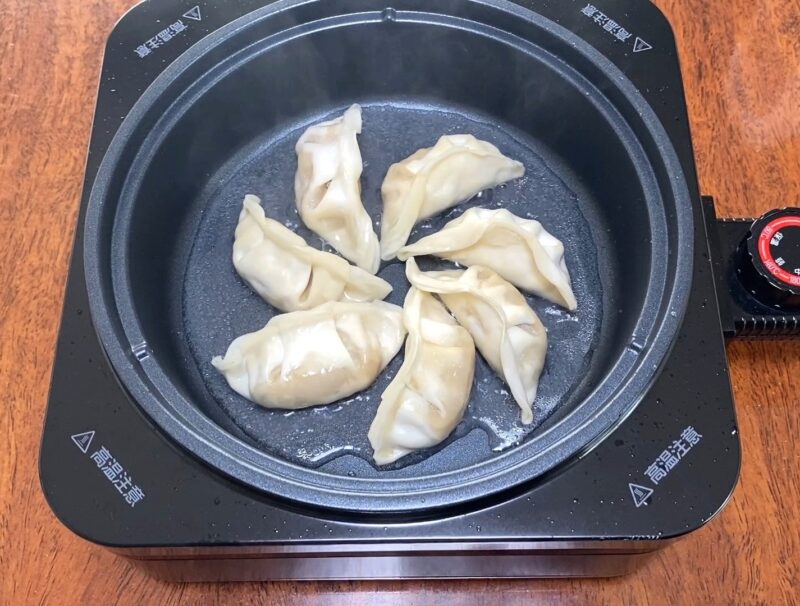 フライパン（ホットプレート）で豚肉餃子を蒸し焼きにしている途中の様子