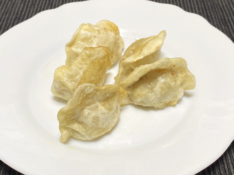 白い皿に盛られた揚げ三鮮水餃子。薄いきつね色の衣がつき、外側がカリッと膨らんだ見た目。