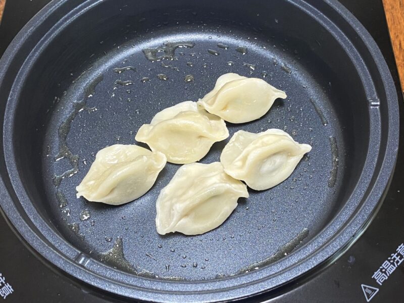 水分が飛んで仕上がった三鮮水餃子の焼き調理。表面に軽い焼き色がついている。