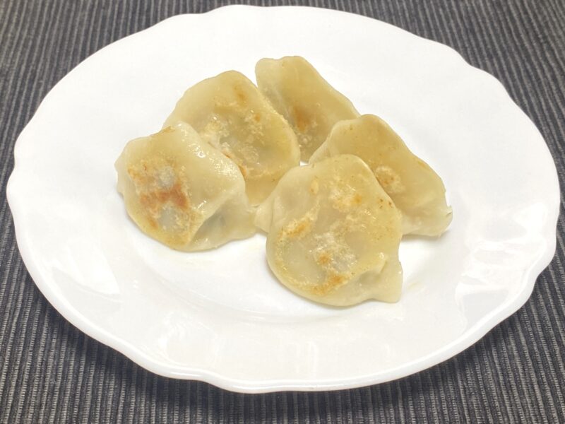 白い皿に並んだ焼き三鮮水餃子。底面にほんのり焼き色がつき、皮は柔らかめで膨らんだ仕上がり。