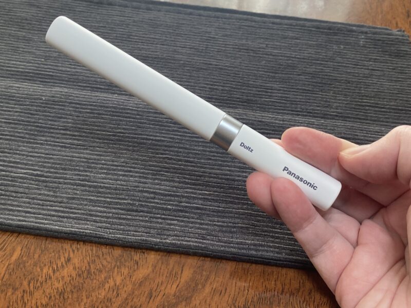 エネループで稼働する小型の電動歯ブラシポケットドルツを手に持っている