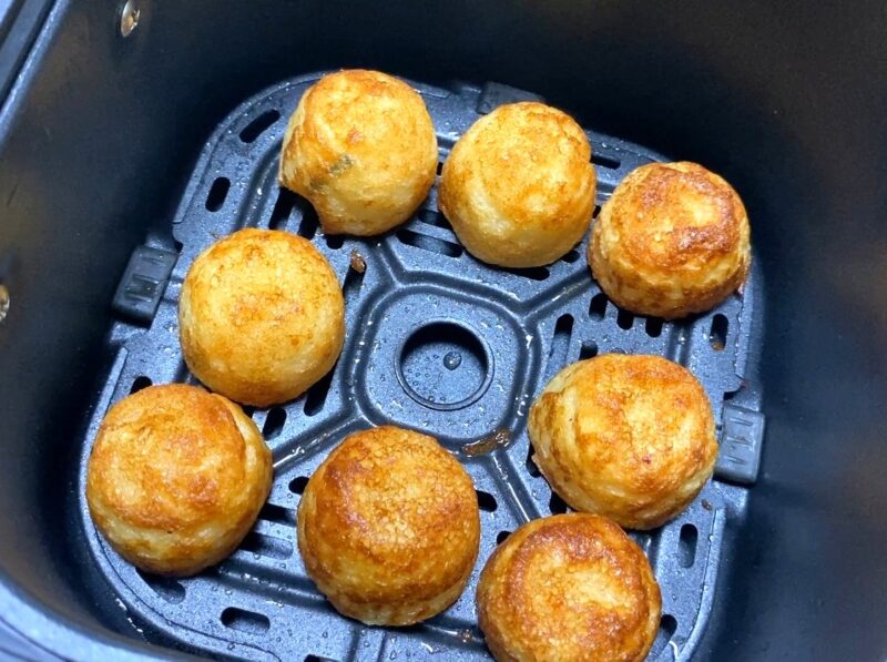 ノンフライヤーで焼き上げた国産冷凍たこ焼き。外側がカリッと色よく焼け、ふわトロ食感が期待できるたこ焼きが並んでいる様子。