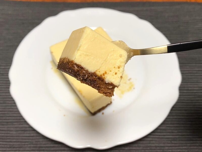 カスタードムースとカラメルスポンジをフォークで持ち上げた一口サイズ。なめらかでおいしそうな質感がよく分かる。