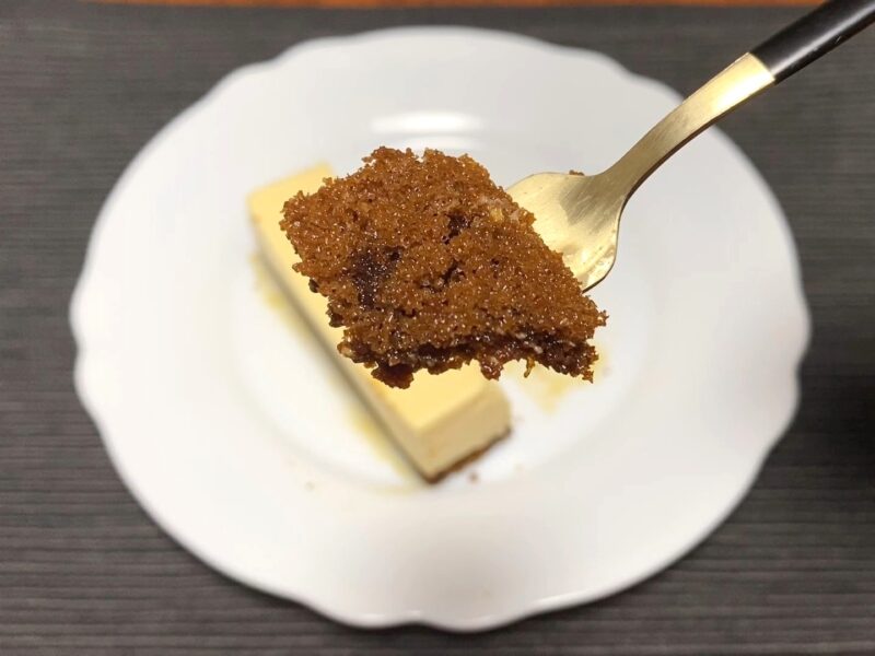 カラメルシロップが染み込んだスポンジ部分をフォークで持ち上げた様子。しっとり濃い色合いが特徴。