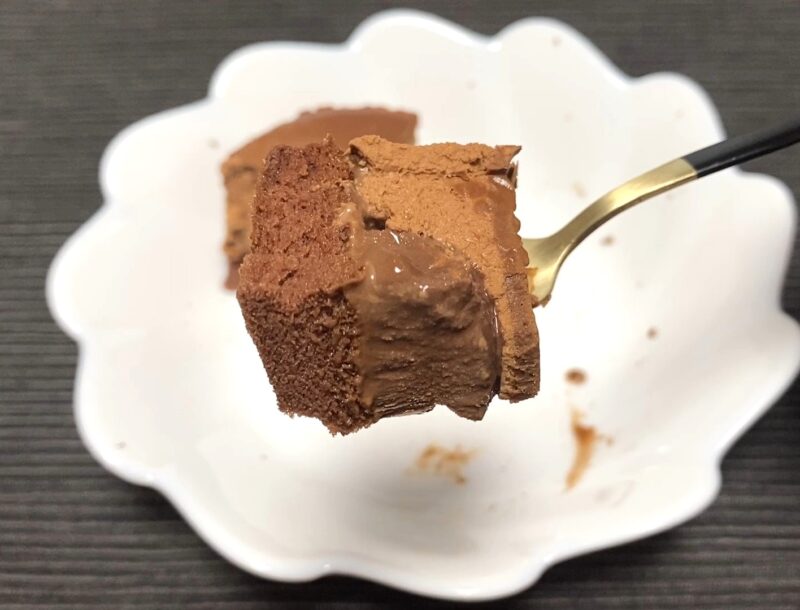 業務スーパー「ガトーショコラの誘惑」の中央部分をフォークで持ち上げた画像。中心の濃厚ショコラがアイスのように締まった質感であることがわかる写真