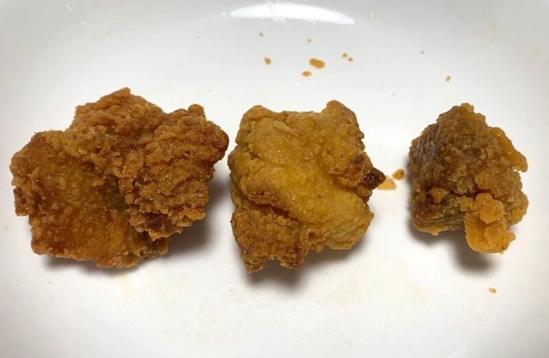 油調理、ノンフライヤー、電子レンジで加熱した唐揚げを横に並べた比較写真。左は衣がカリッと濃い色、中央はやや明るくサクッとした表面、右は電子レンジ加熱でしっとり柔らかい見た目になっている。