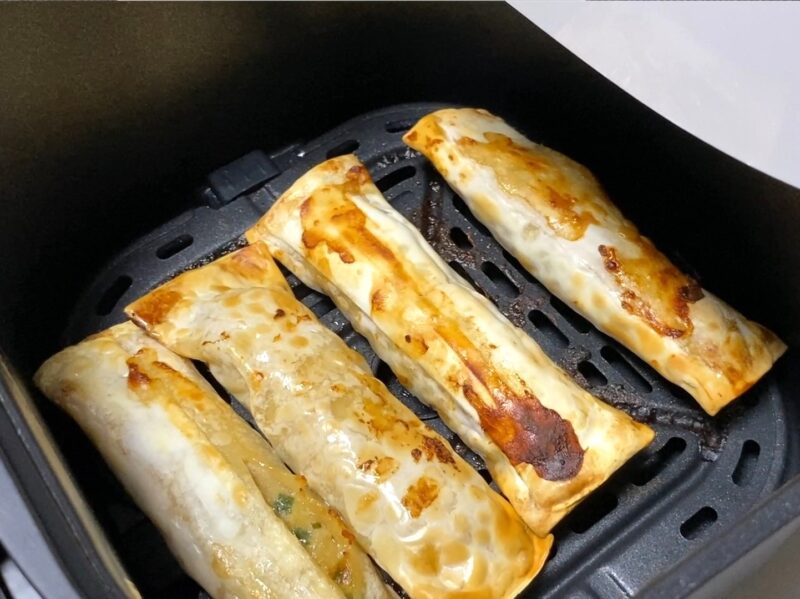 ノンフライヤーのバスケットに並べられた冷凍棒餃子