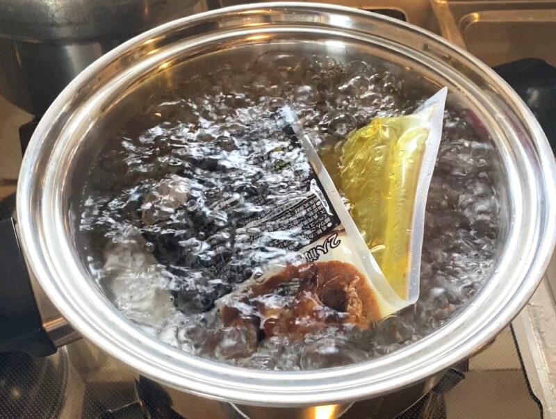 沸騰したお湯で湯せん調理中の角煮カレー パックのまま5分加熱