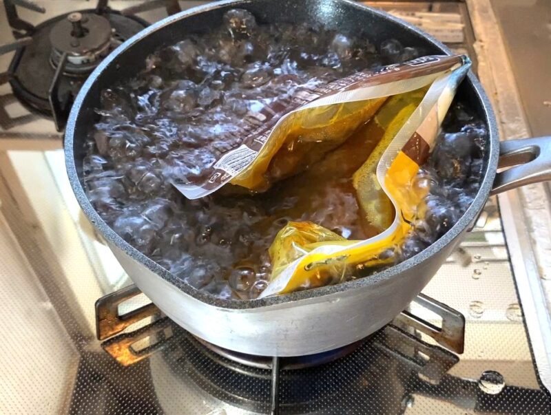 鍋で湯せん調理中のスパイシーカレーチキン 温め時間約5分