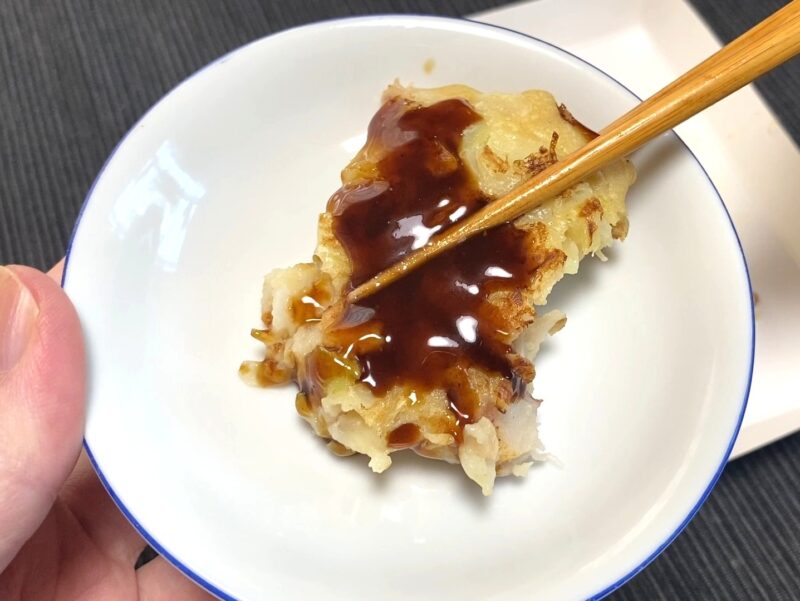 特製ソースを塗ったお好み焼き を食べる