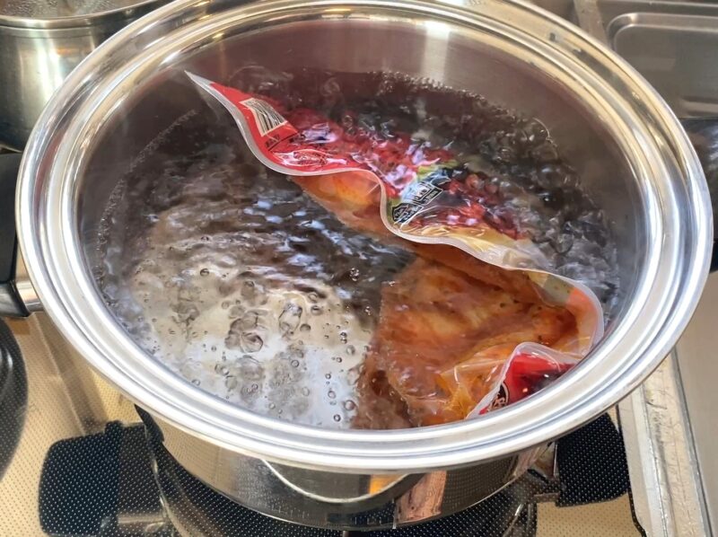 袋のまま湯せん調理中のピリピリチキン 温め時間約5分