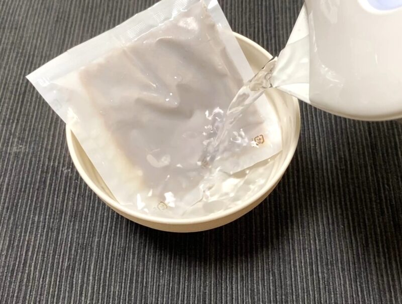 スープ袋をカップのお湯で湯煎解凍する工程