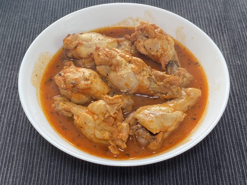 盛り付けたピリピリチキン 赤いキムチだれが絡んだ骨付き手羽元