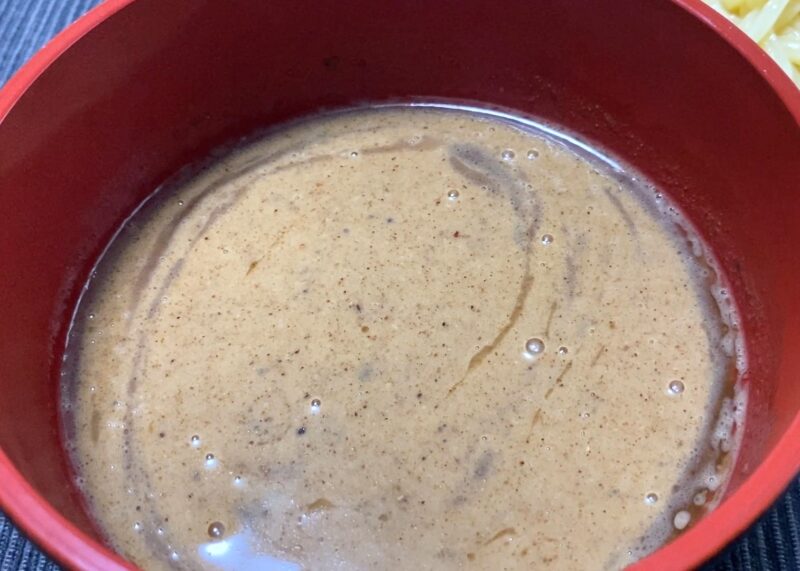 魚粉が浮いた濃厚魚介豚骨スープのアップ