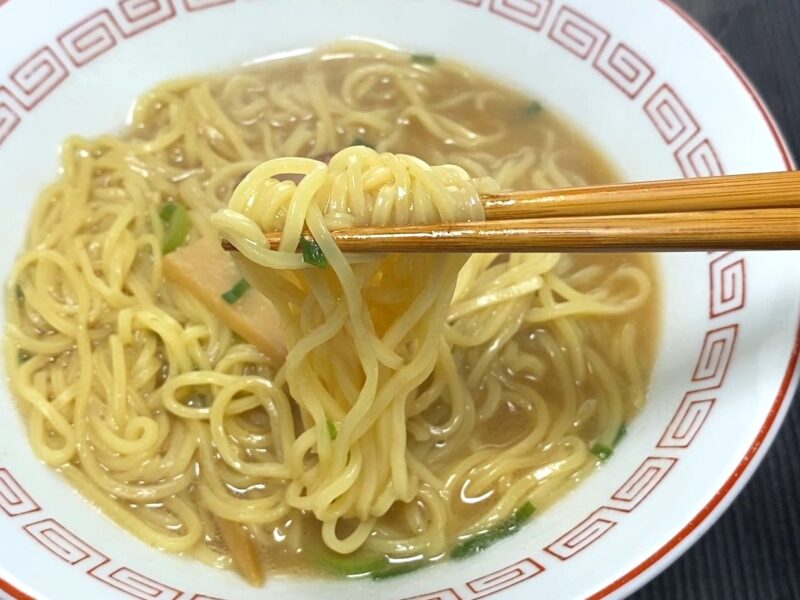 箸で持ち上げた歯切れの良い細麺 スープがしっかり絡んだ状態