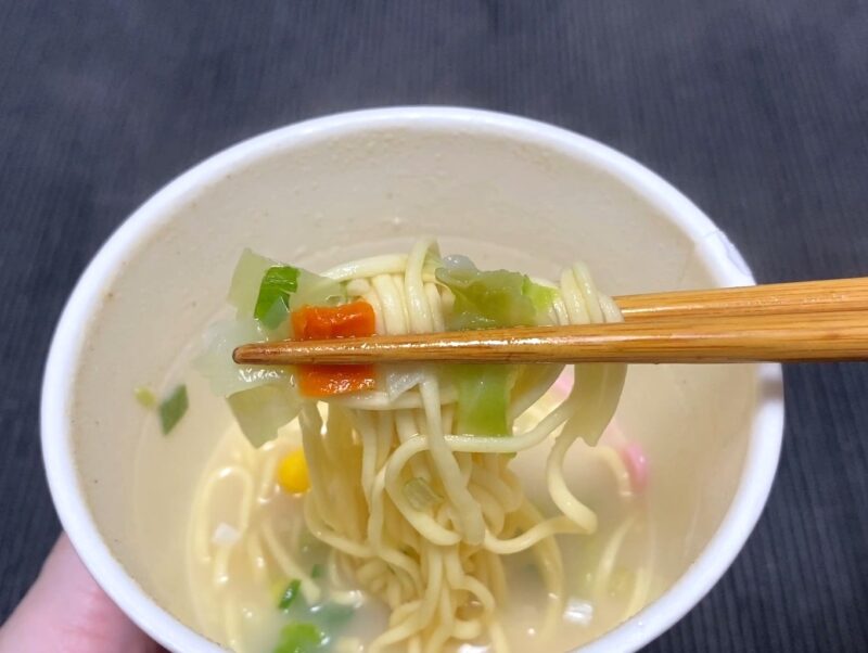 箸でつまんだ野菜ちゃんぽんの麺と具材。キャベツ・人参・ねぎが絡まった状態のアップ