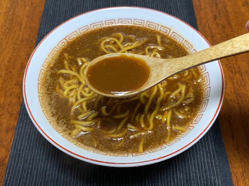 山岡家乾麺・味噌のスープをレンゲですくった様子・濃厚な濃茶色のスープ