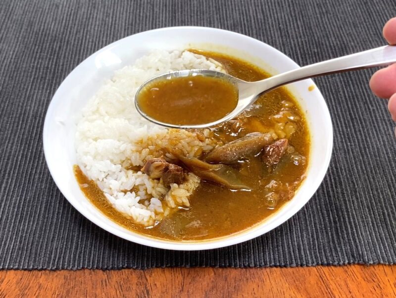 業務スーパー・牛すじとこんにゃくの和風カレーのルーをスプーンですくった様子・さらっとした和風だし系のスープ