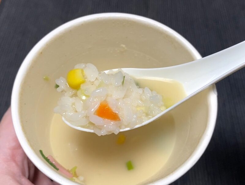 野菜ちゃんぽんのスープにご飯を追加したアレンジ。レンゲにご飯とコーン・人参が乗っている