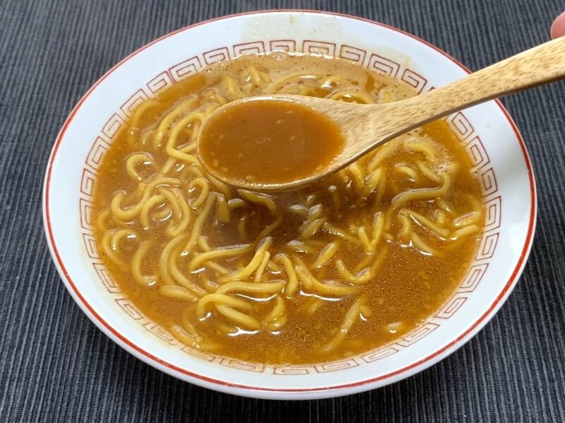 山岡家乾麺・特製味噌のスープをレンゲですくった様子・白味噌のコクある茶色いスープ
